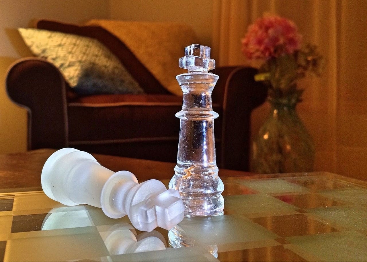 Image of one chess piece tipped over and one standing up.