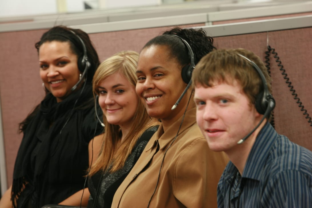 Image of four smiling answering service agents