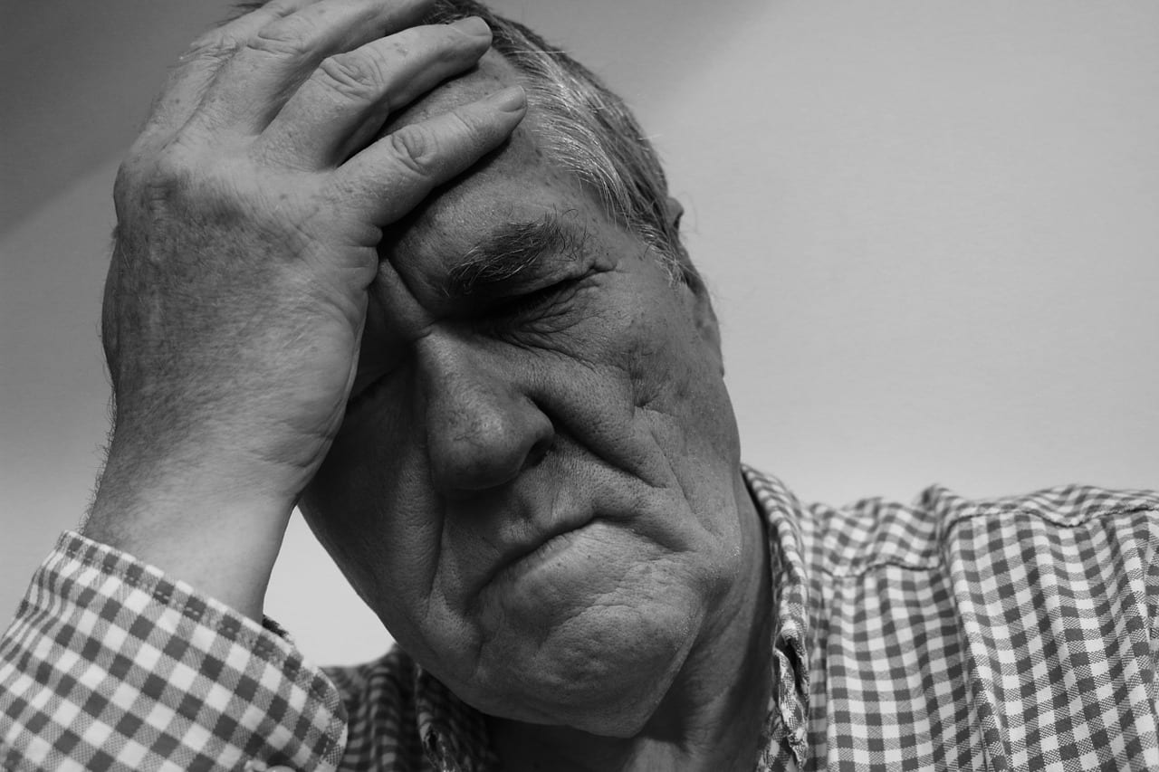 Image of a man with his hand on his head who can't speak but can communicate with an answering service