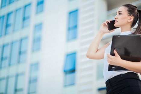 business women on her phone outside building