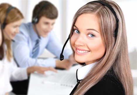 Customer service representative smiling with colleagues in the background