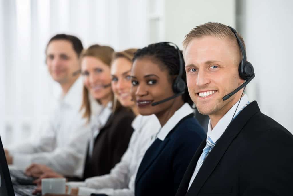 Team Of Businesspeople With Headsets Working In Call Center Office