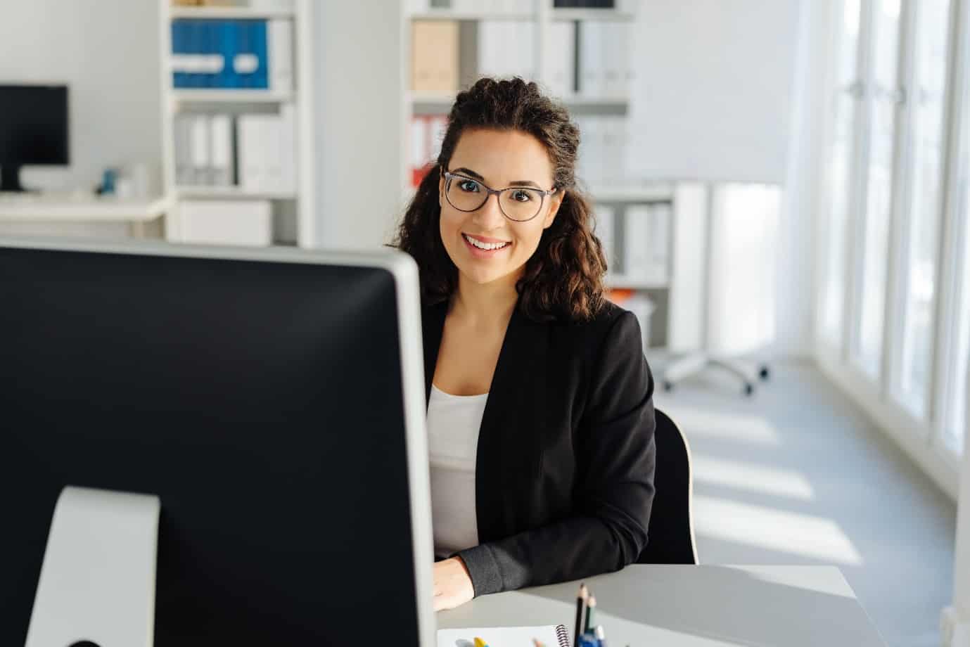 Young businesswoman sitting working at a desktop computer in the office