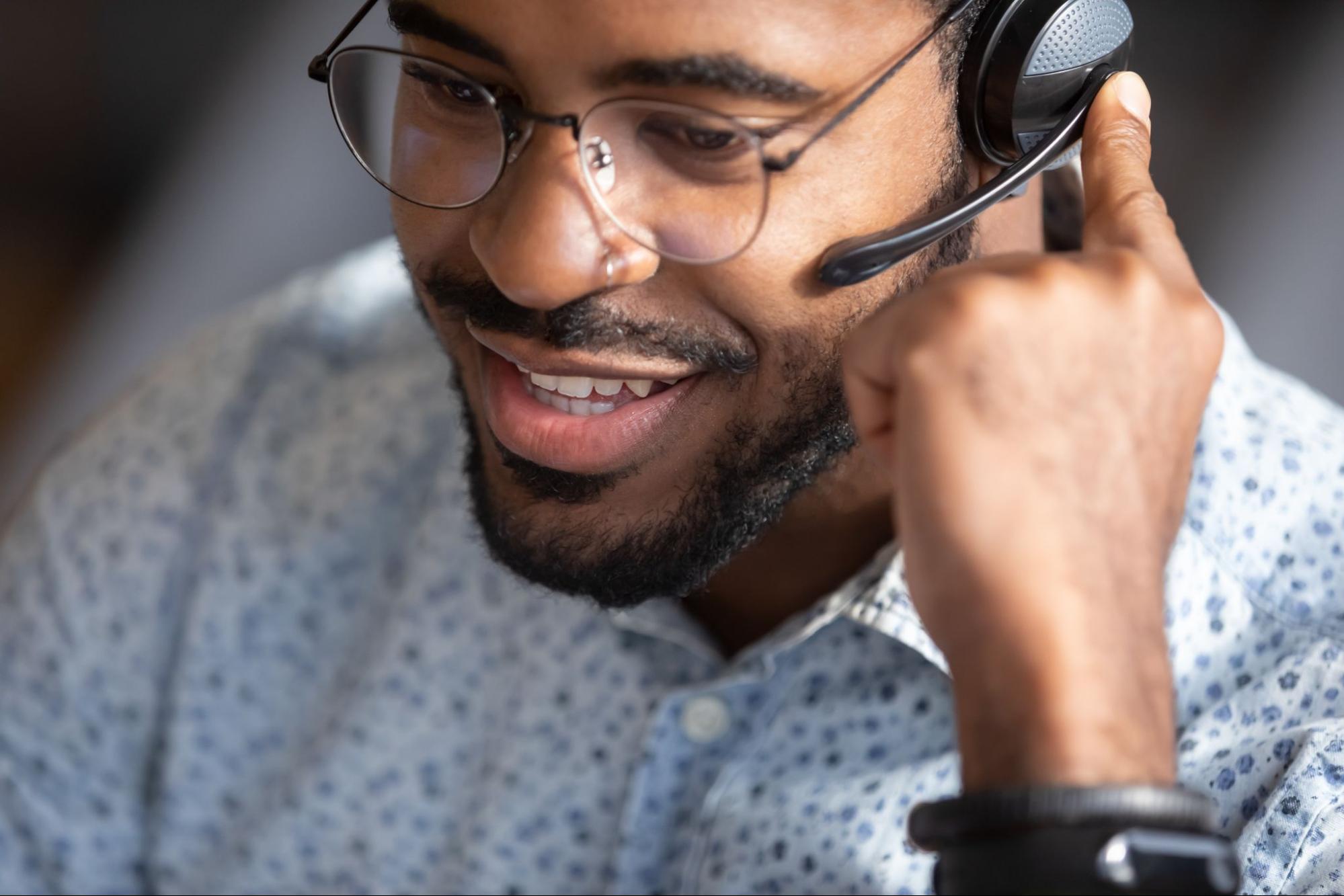 Receptionist wearing headset contacting customers to inform them about service, answer questions about products.