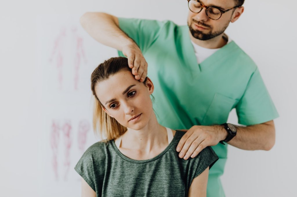 Chiropractor examining patient in chiropractic office