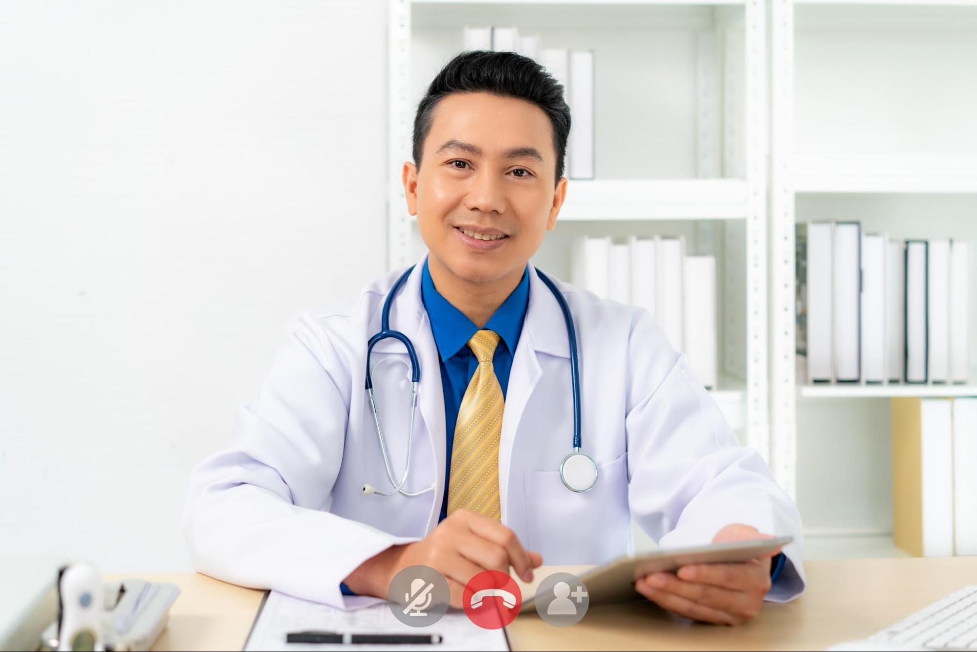 Smiling doctor with digital tablet looking at camera.