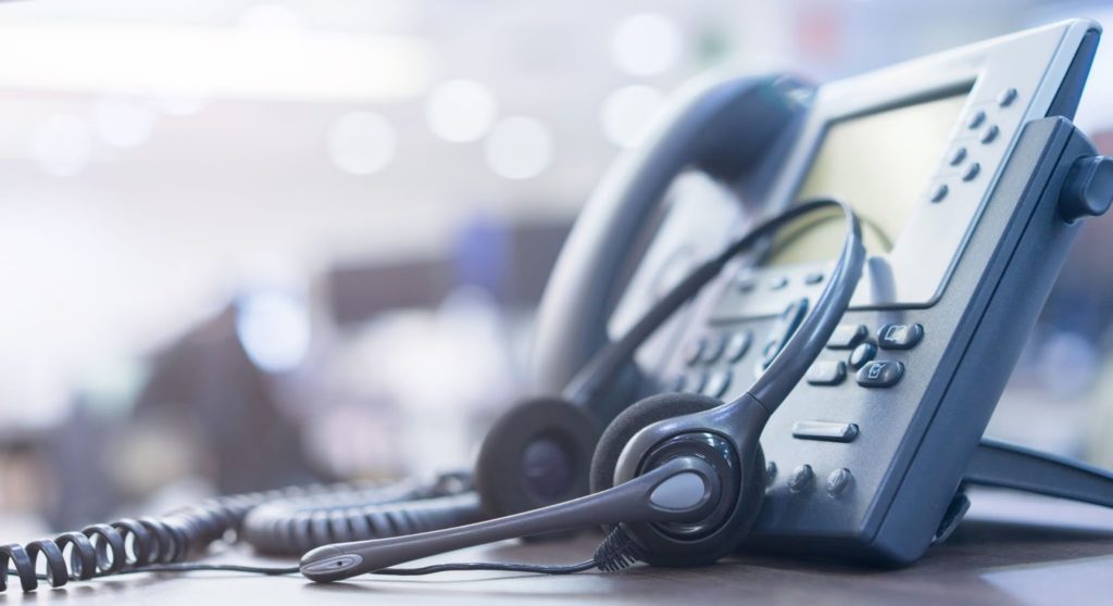 Landline telephone with headset at office.