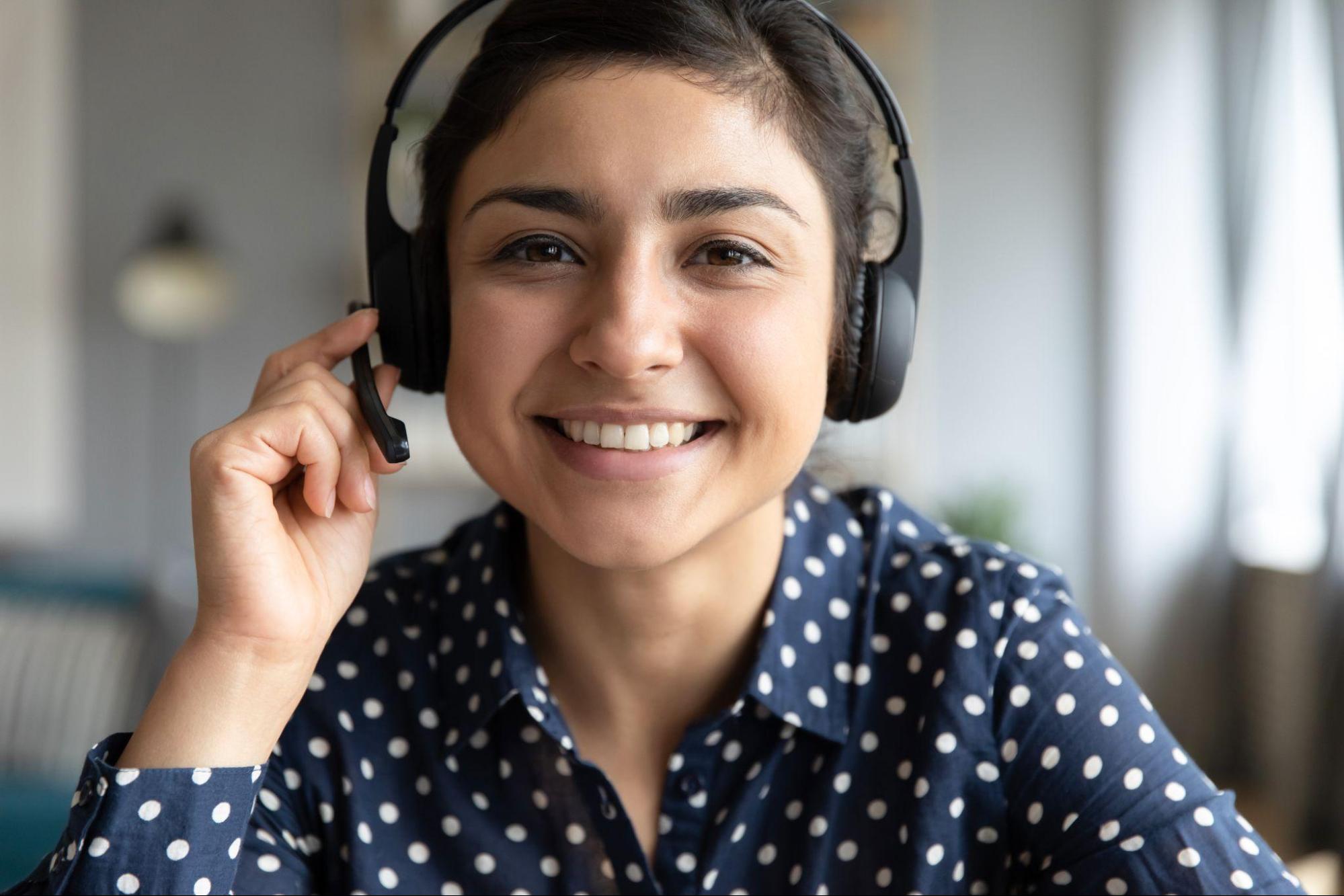 Smiling girl agent wear wireless headset look at camera