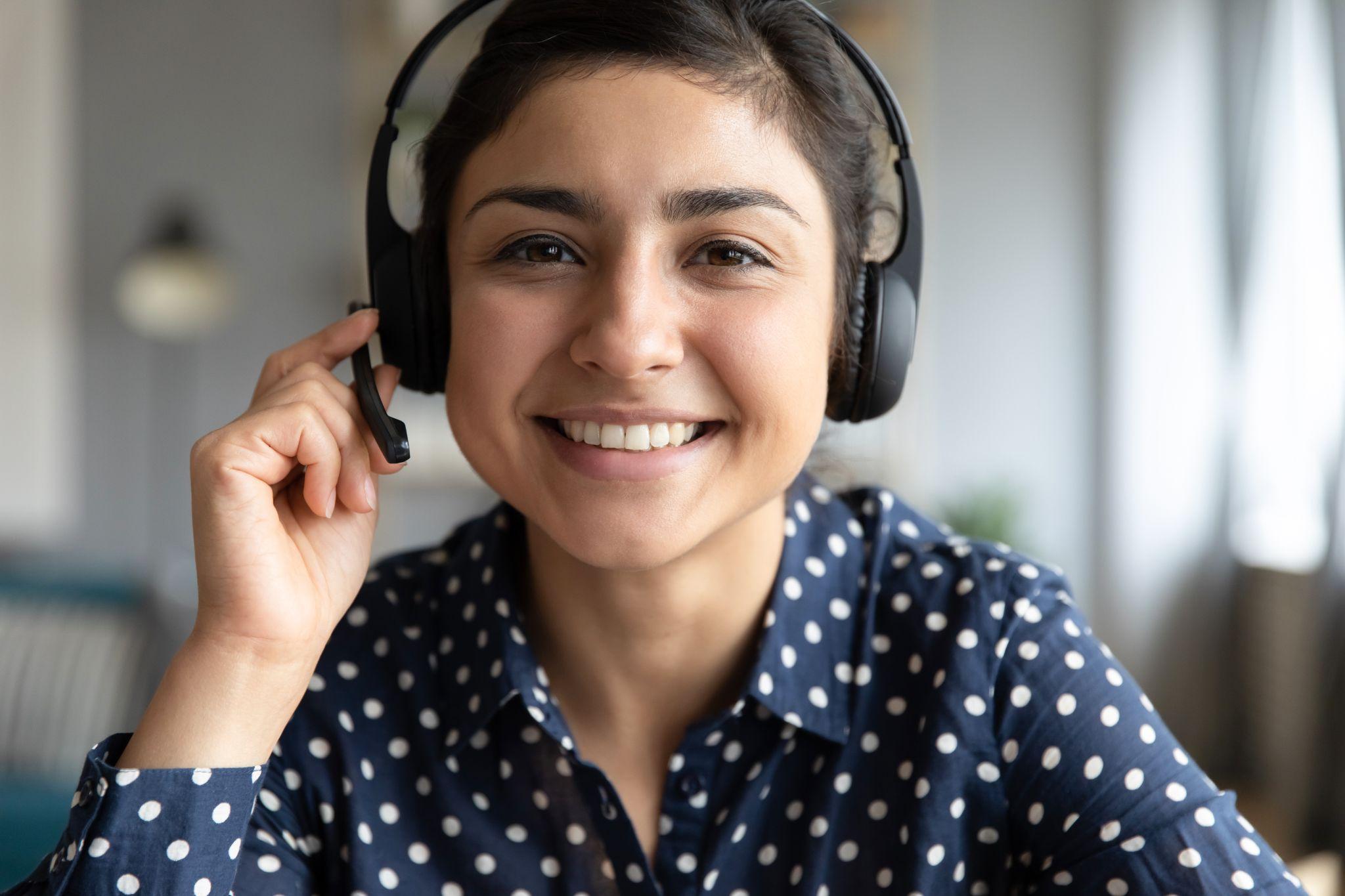 Smiling girl agent wear wireless headset look at camera