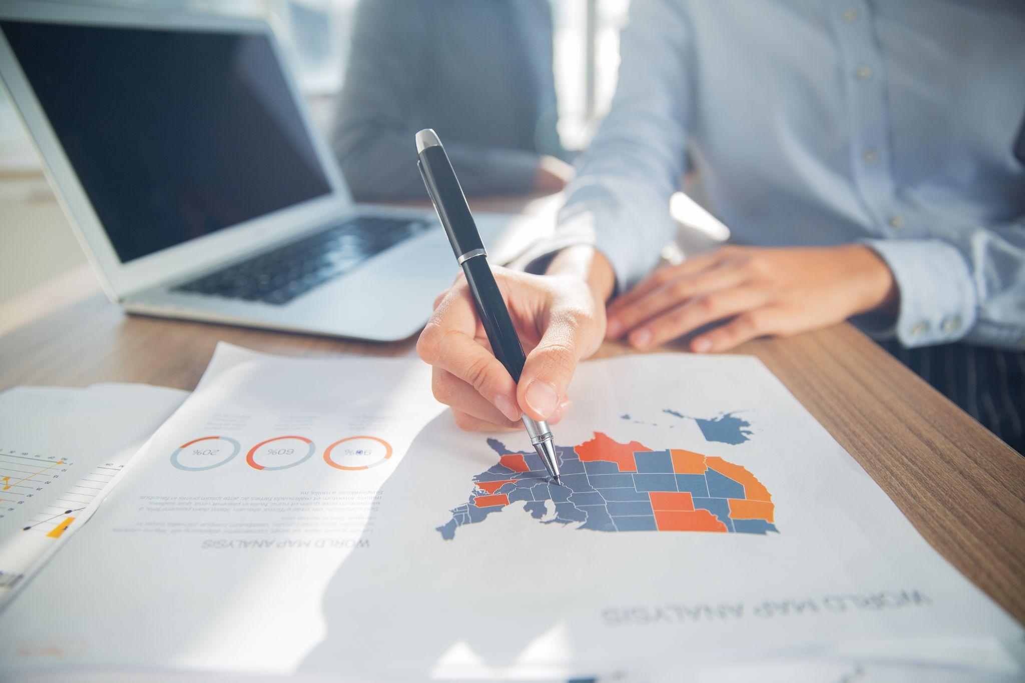 Hand of businesswoman pointing at USA map on paper