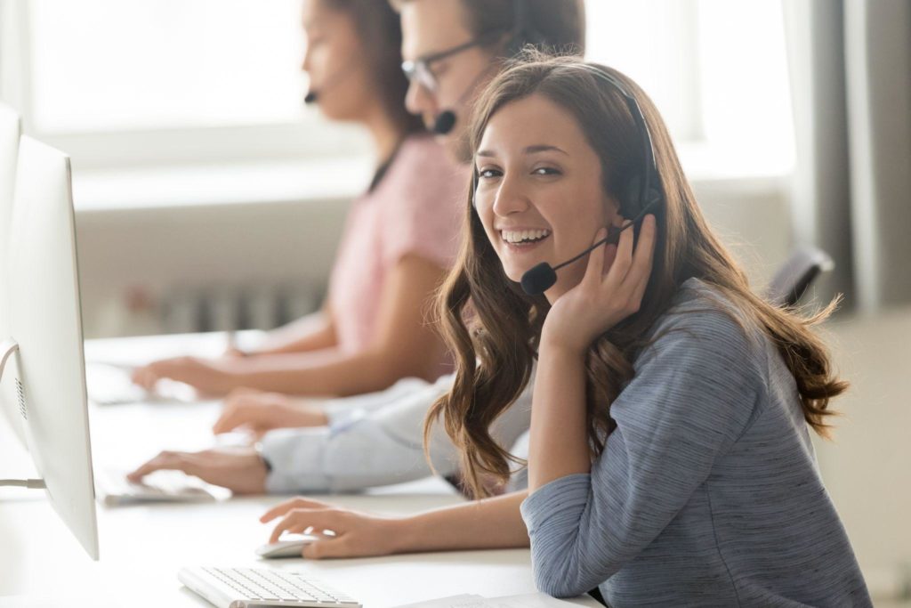 Call center employee female sitting at workplace pose for camera