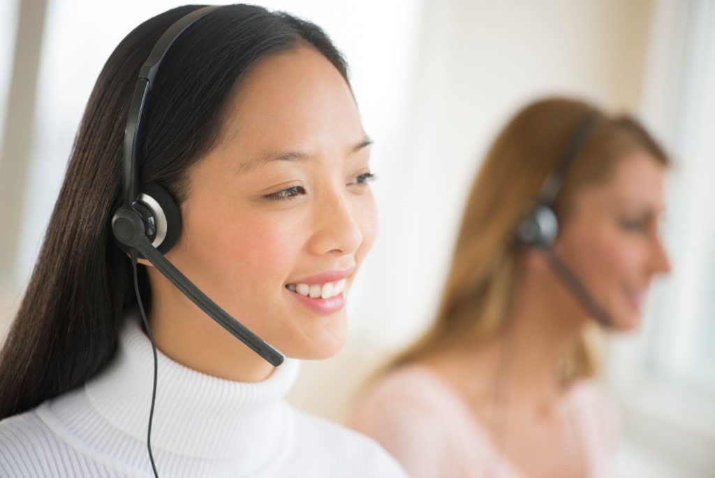 Happy female customer service representative looking away