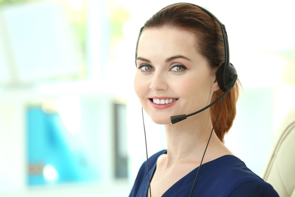 Young female technical support dispatcher working in office