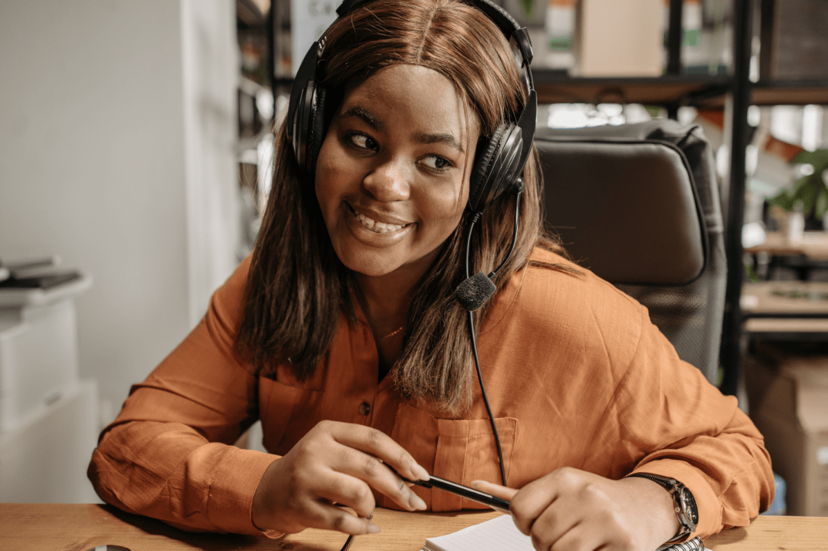 Female customer service agent with headset and brown shirt.