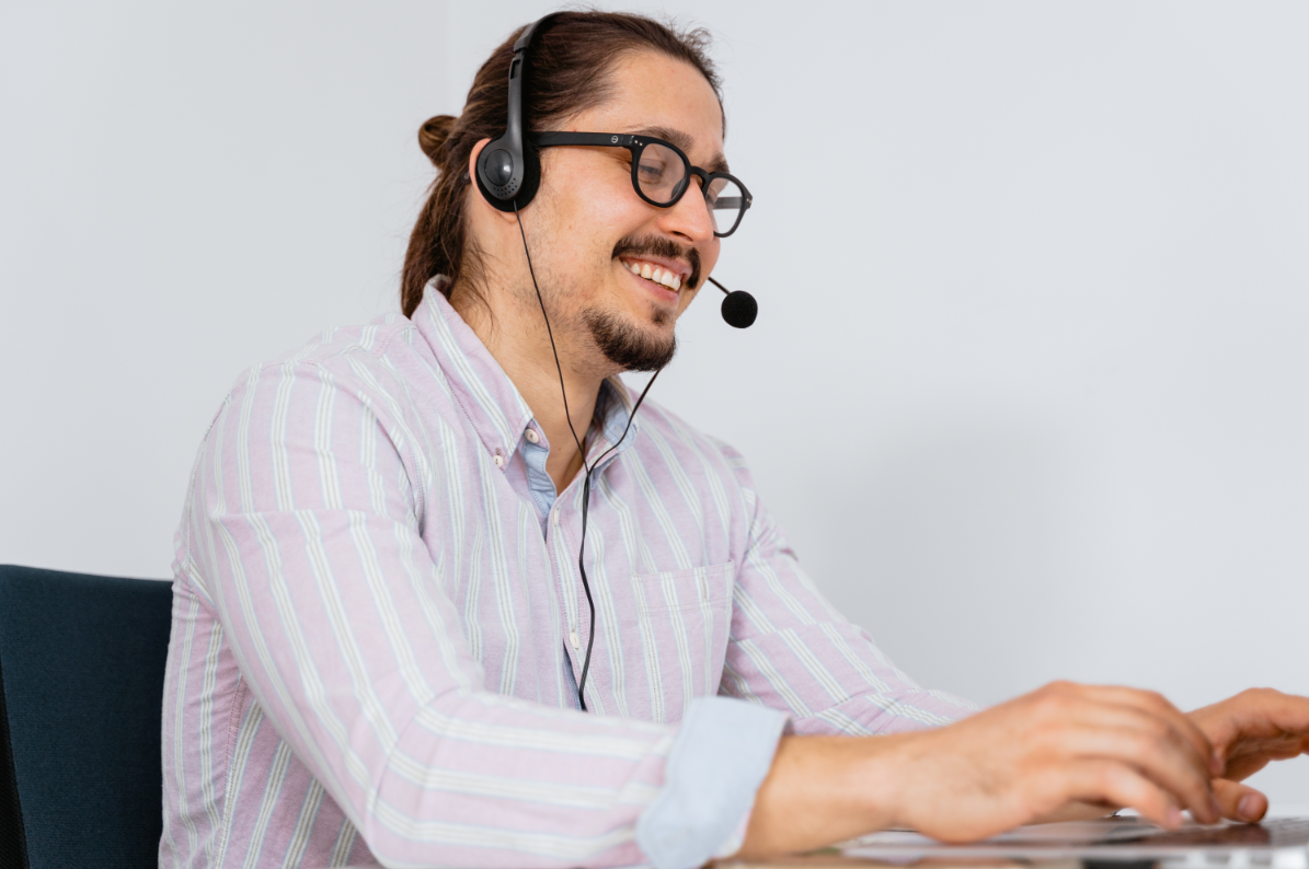 Male customer service agent with headset and striped shirt.