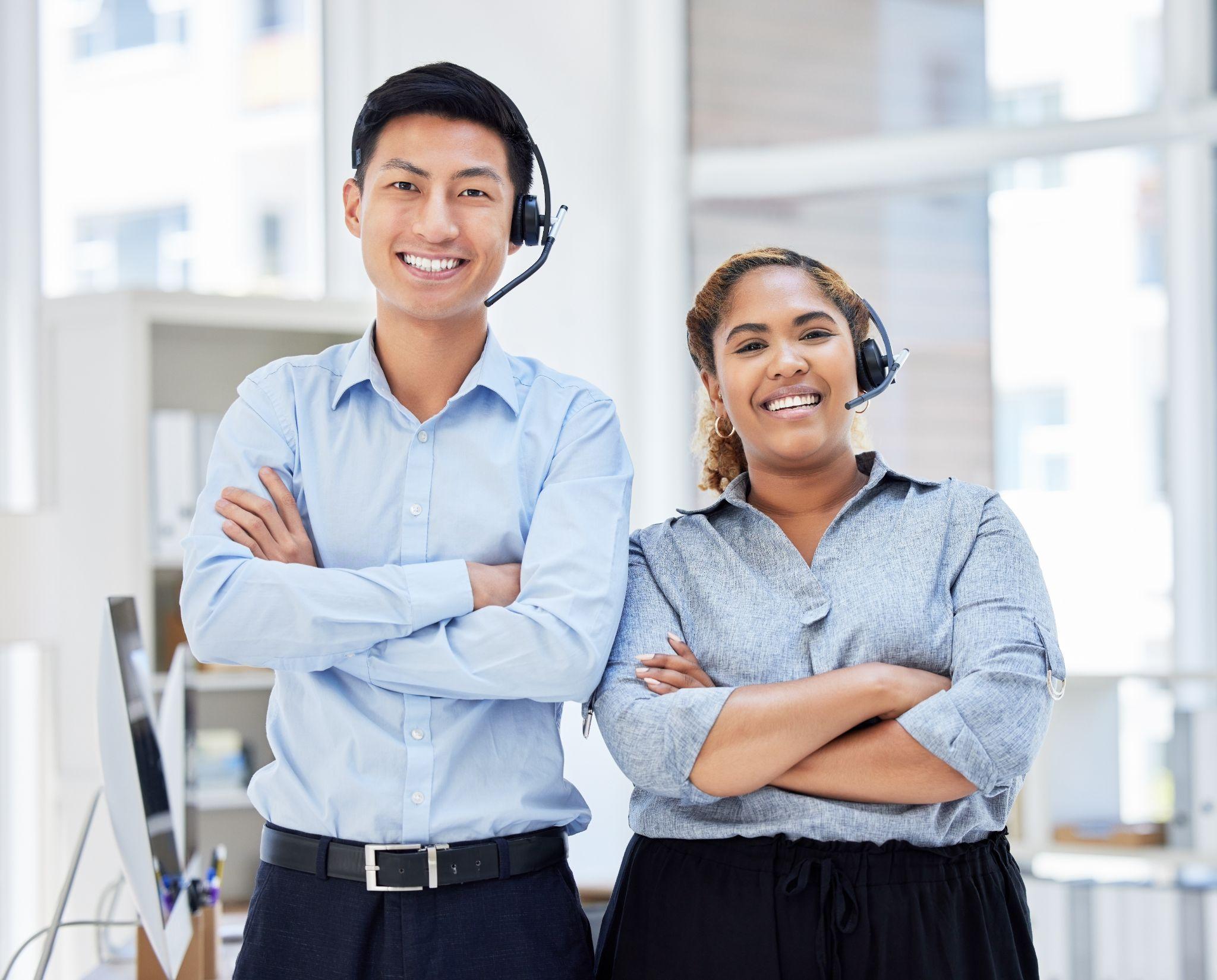 Two answering service agents with crossed arms and headsets.