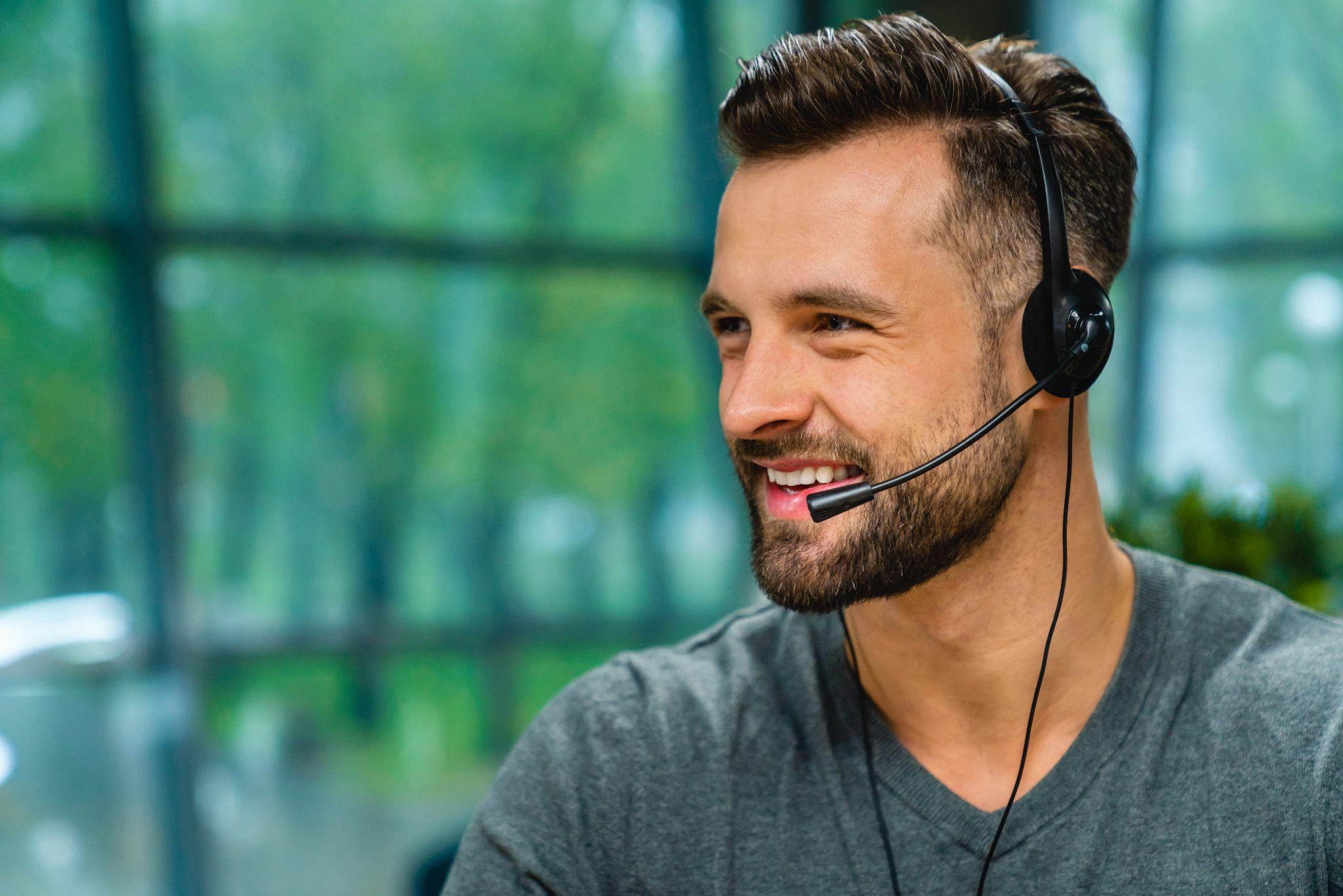 Man with headset during working process in spacious office.