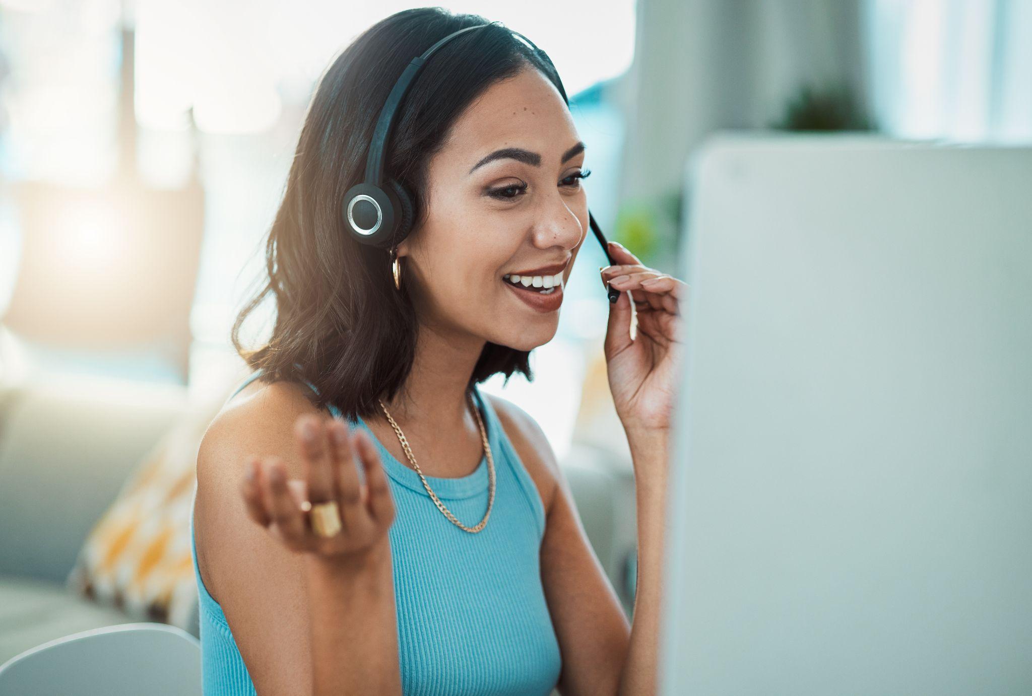 A woman in a headset smiles when answering the phone, showing how to speak clearly and be an active listener.