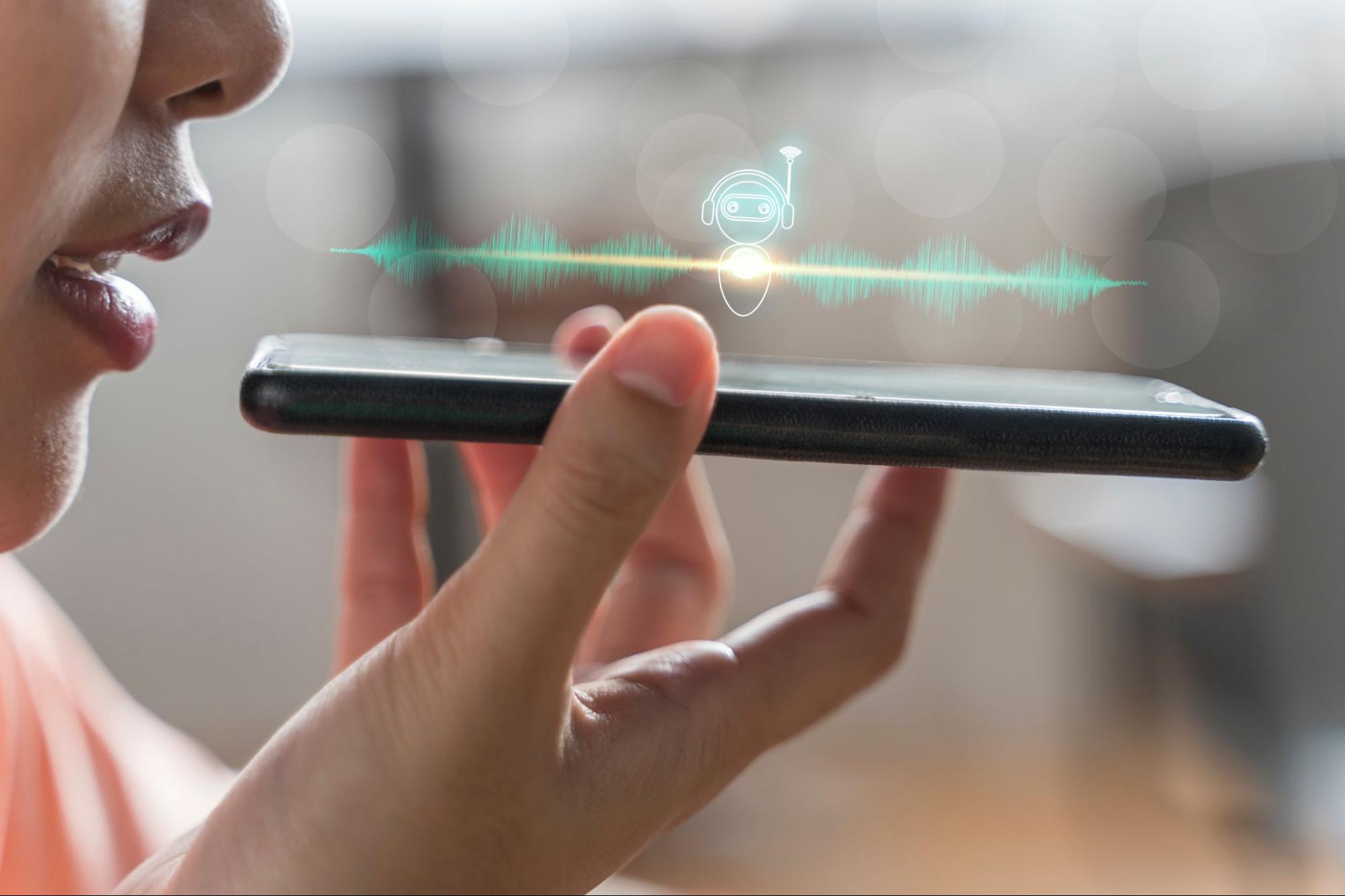 Close up of pretty woman holding in hand smart phone talking with digital assistant.