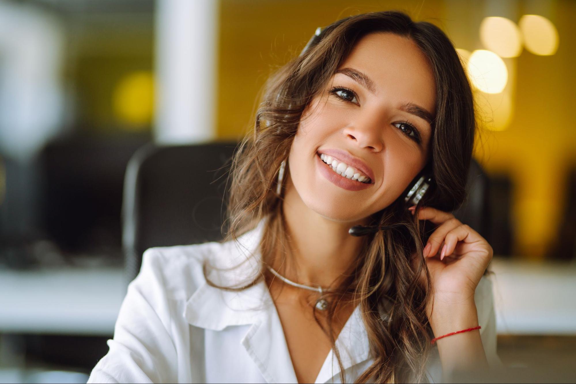 Young operator woman with headsets working in a call center.